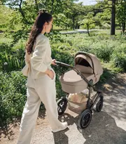 En kvinna som går med en britax römer vagn