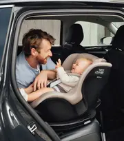 En man med sitt barn i en bilbarnstol från britax