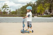 en pojke med cykelhjälm på en sparkcykel
