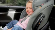 Barn sitter säkert i en bakåtvänd bilbarnstol i bilen.