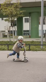 en pojke med cykelhjälm på en sparkcykel
